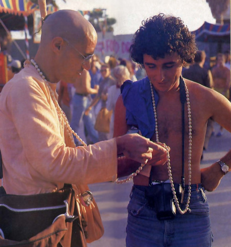 Hare Krishna Devotee Showing Young Man How to Chant Hare Krishna on Japa Beads